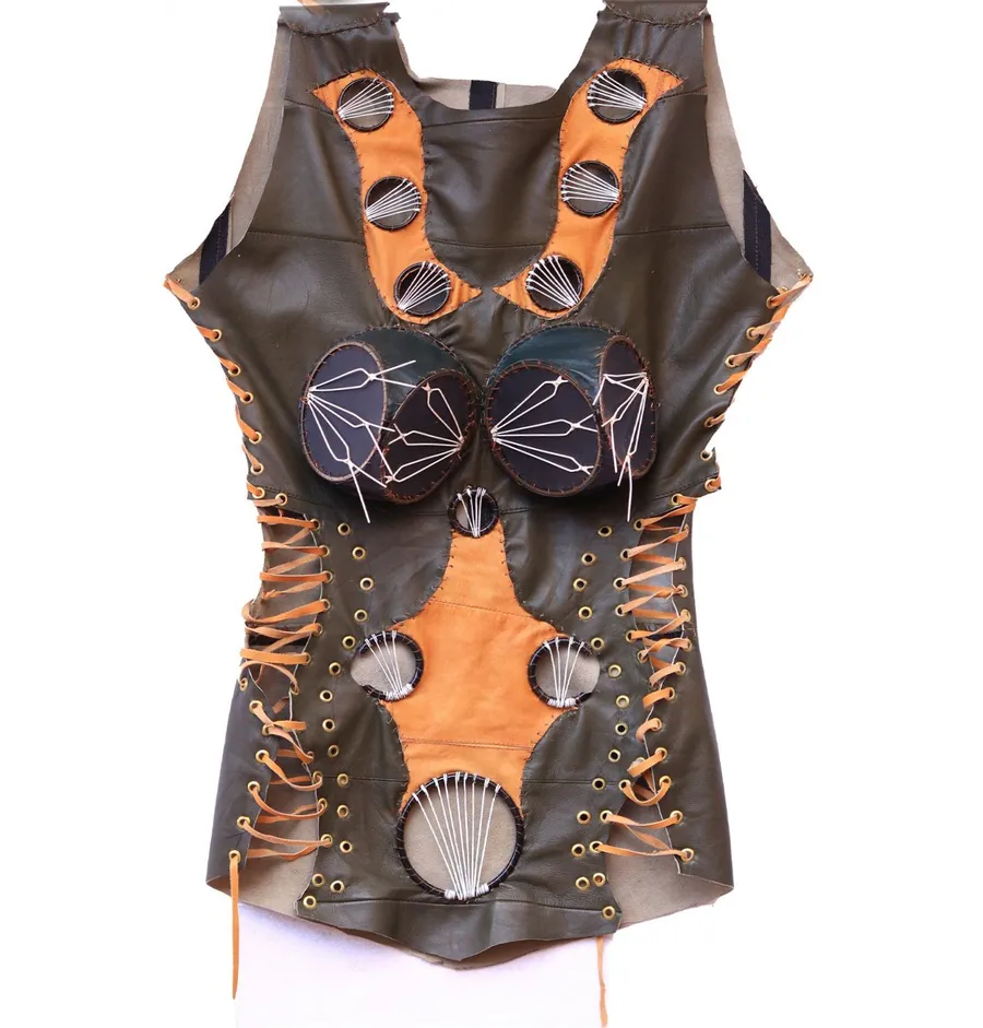 A laced leather bodice in dark brown and burnt orange panels with a scallop shell set at the waist and cut discs across the chest