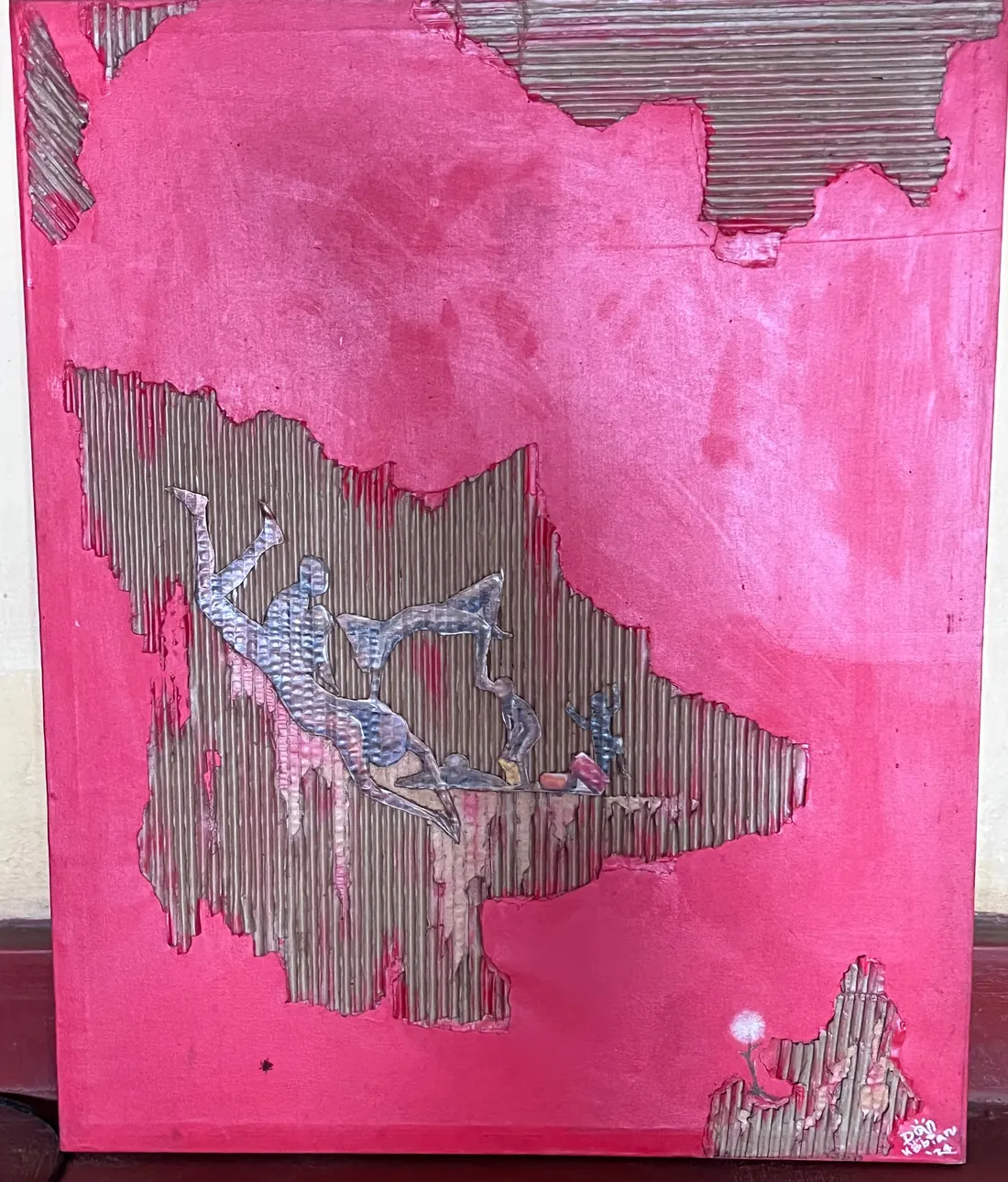 A hot pink panel torn open to expose the corrugations beneath, with small hammered metal figures set into the opening