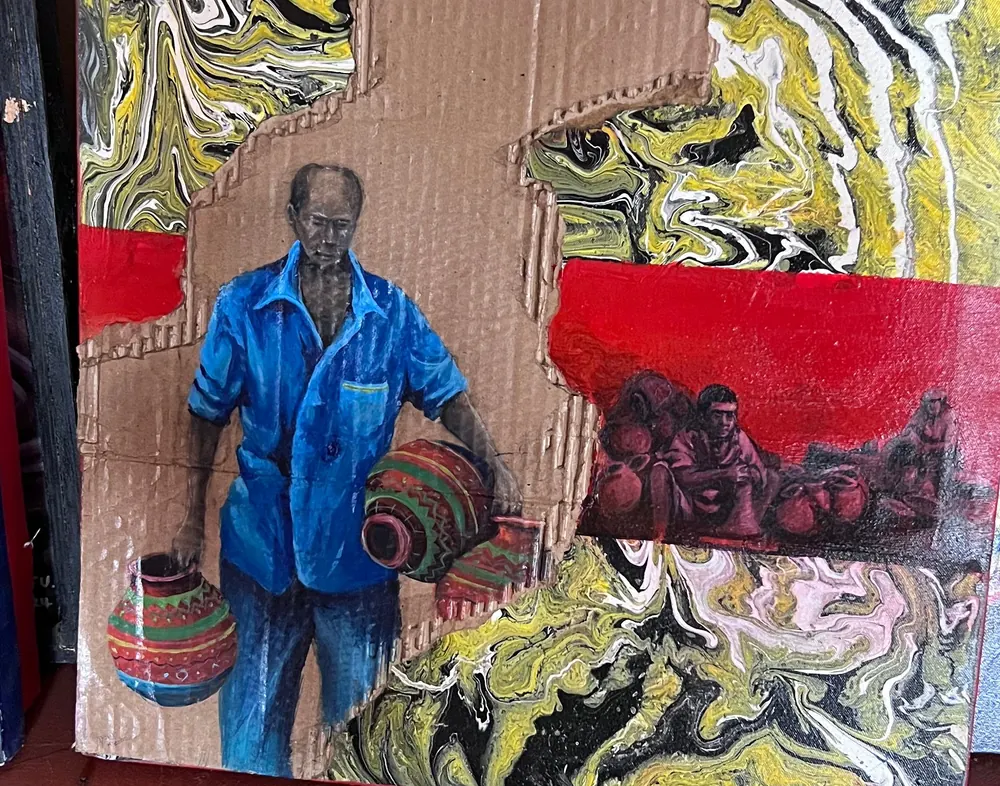 A potter in a blue shirt carrying two patterned clay vessels, painted on corrugated cardboard set into a ground of poured yellow, black and white paint with red bands