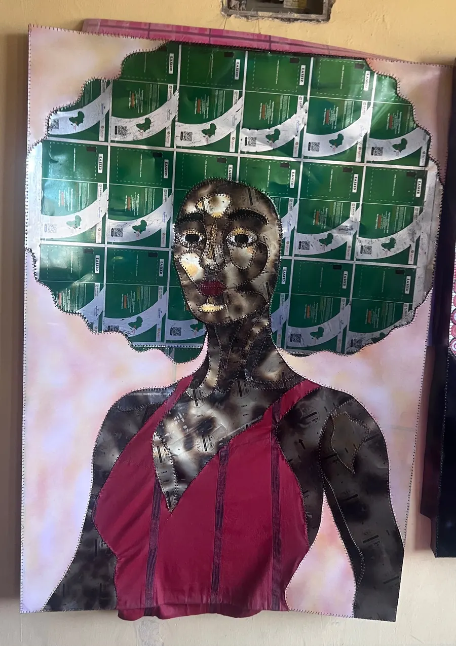 Stitched portrait with a crown of green seed packets and a deep red fabric dress