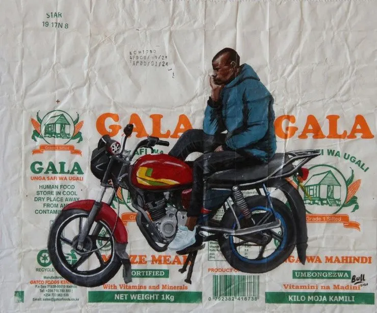 A man in a blue hooded jacket sitting sideways on a red motorcycle with his hand to his head, painted across two flattened Gala maize meal packets