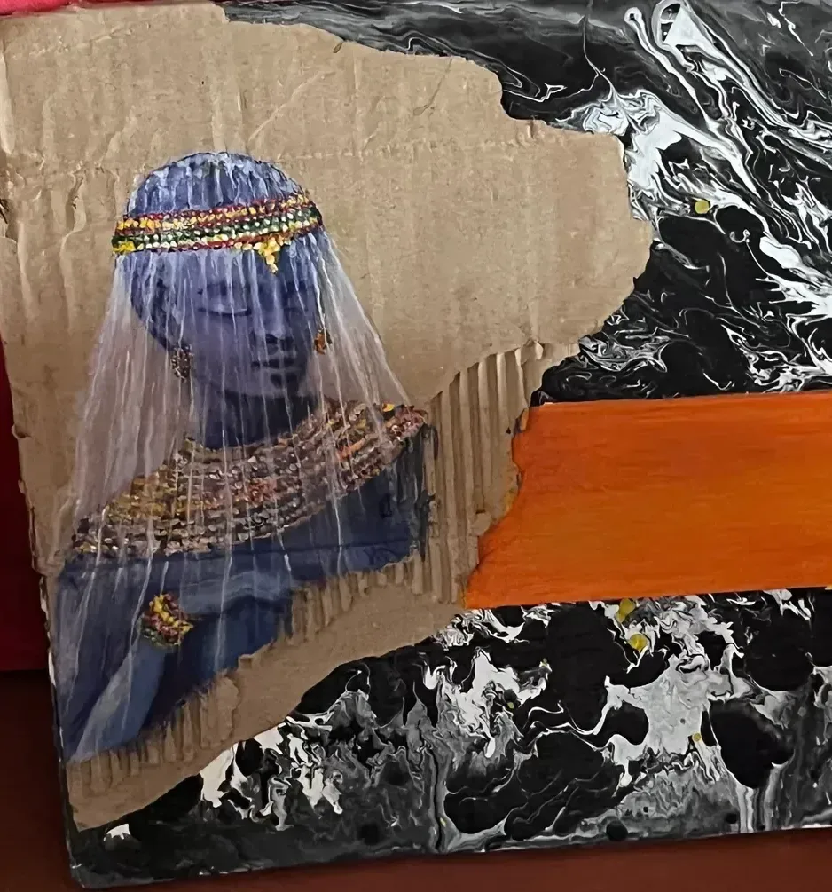 A veiled figure in deep blue with a beaded headdress, cut from corrugated cardboard and set against a poured black and white ground crossed by a single orange band