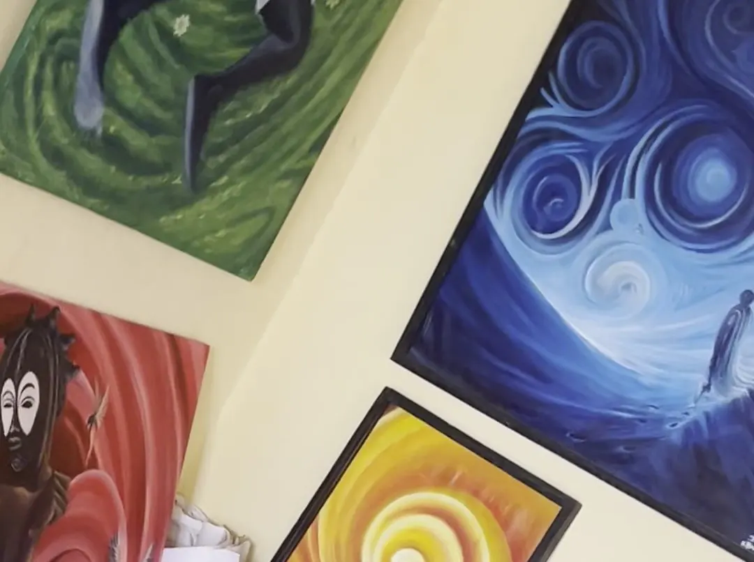 Canvases hung and stacked against the studio wall, ready to move